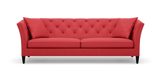 The Shelton 98" Sofa features a red color with a tufted backrest and two seat cushions, along with stylish flare arms. It rests on dark wooden legs and embodies a modern, elegant design.