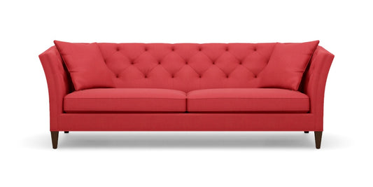 Introducing the Shelton 98" Sofa: a contemporary red sofa featuring a tufted backrest and two seat cushions. It showcases angled armrests, rests on four dark wooden legs, and comes complete with two coordinating red throw pillows at each end.