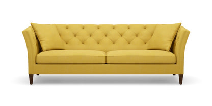 The Shelton 98" Sofa features a mustard yellow tufted design with two seat cushions and two back cushions. It has high arms and dark wooden legs, all set against a plain white background.