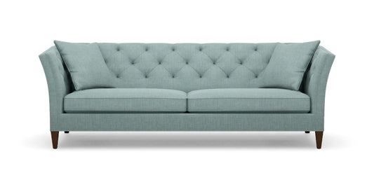 The Shelton 98" Sofa boasts a light teal color with tufted upholstery, featuring an angled backrest and cushions. Its wooden legs and contemporary design offer a stylish and comfortable two-seat seating option.