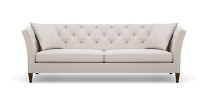 The Shelton 98" Sofa is a light gray tufted sofa with two cushions, showcasing a modern design with angled armrests and dark wooden legs, set against a white background.