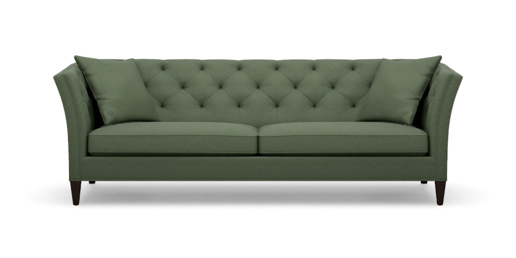 The Shelton 98" Sofa is a green, mid-century modern piece featuring a tufted backrest and angled arms. It includes two large cushions and rests on four dark wooden legs.