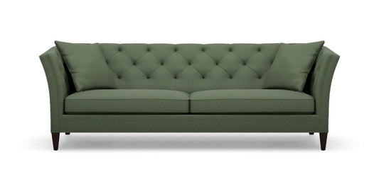 The Shelton 98" Sofa is a green, mid-century modern piece featuring a tufted backrest and angled arms. It includes two large cushions and rests on four dark wooden legs.