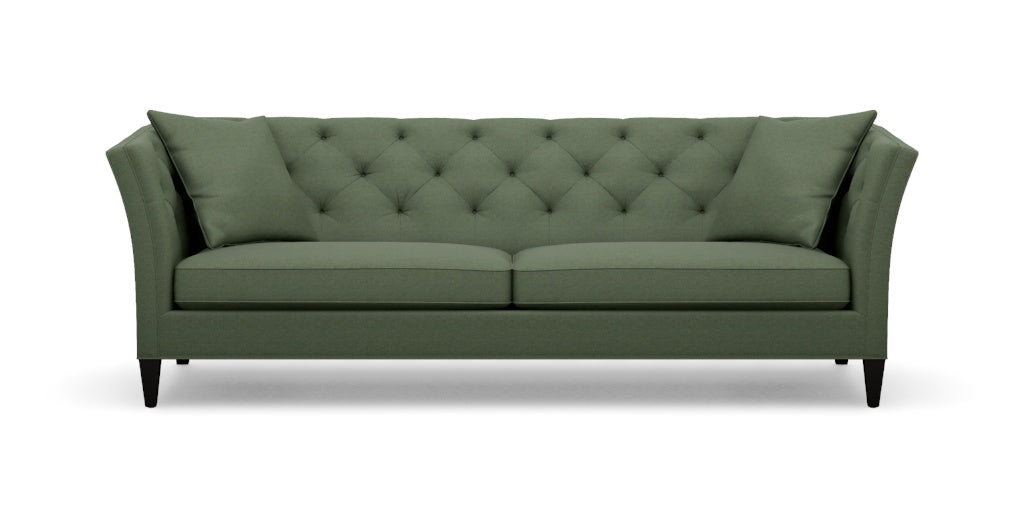 Introducing the Shelton 98" Sofa: a green tufted masterpiece accompanied by two matching cushions. This design boasts high arms and a sleek, modern aesthetic, complete with dark wooden legs and a cozy, plush appearance.