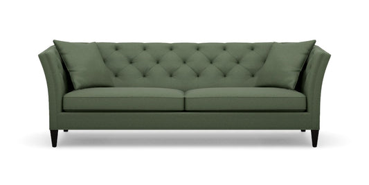 Introducing the Shelton 98" Sofa: a green tufted masterpiece accompanied by two matching cushions. This design boasts high arms and a sleek, modern aesthetic, complete with dark wooden legs and a cozy, plush appearance.