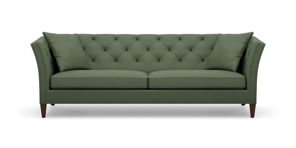 Introducing the Shelton 98" Sofa: This green, tufted sofa includes two seat cushions and two back pillows. It showcases a modern design with tall, angled armrests and tapered wooden legs.