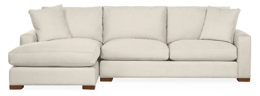 The Metro Sofas with Chaise is a light beige sectional featuring three cushions and a left-side chaise lounge. It boasts rectangular arms and wooden block feet, offering a modern and minimalist aesthetic.