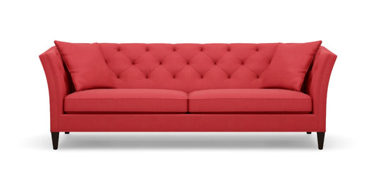 Introducing the Shelton 98" Sofa: a stunning red tufted design complete with two cushions, flared arms, and dark wooden legs, all showcased against a plain white background.