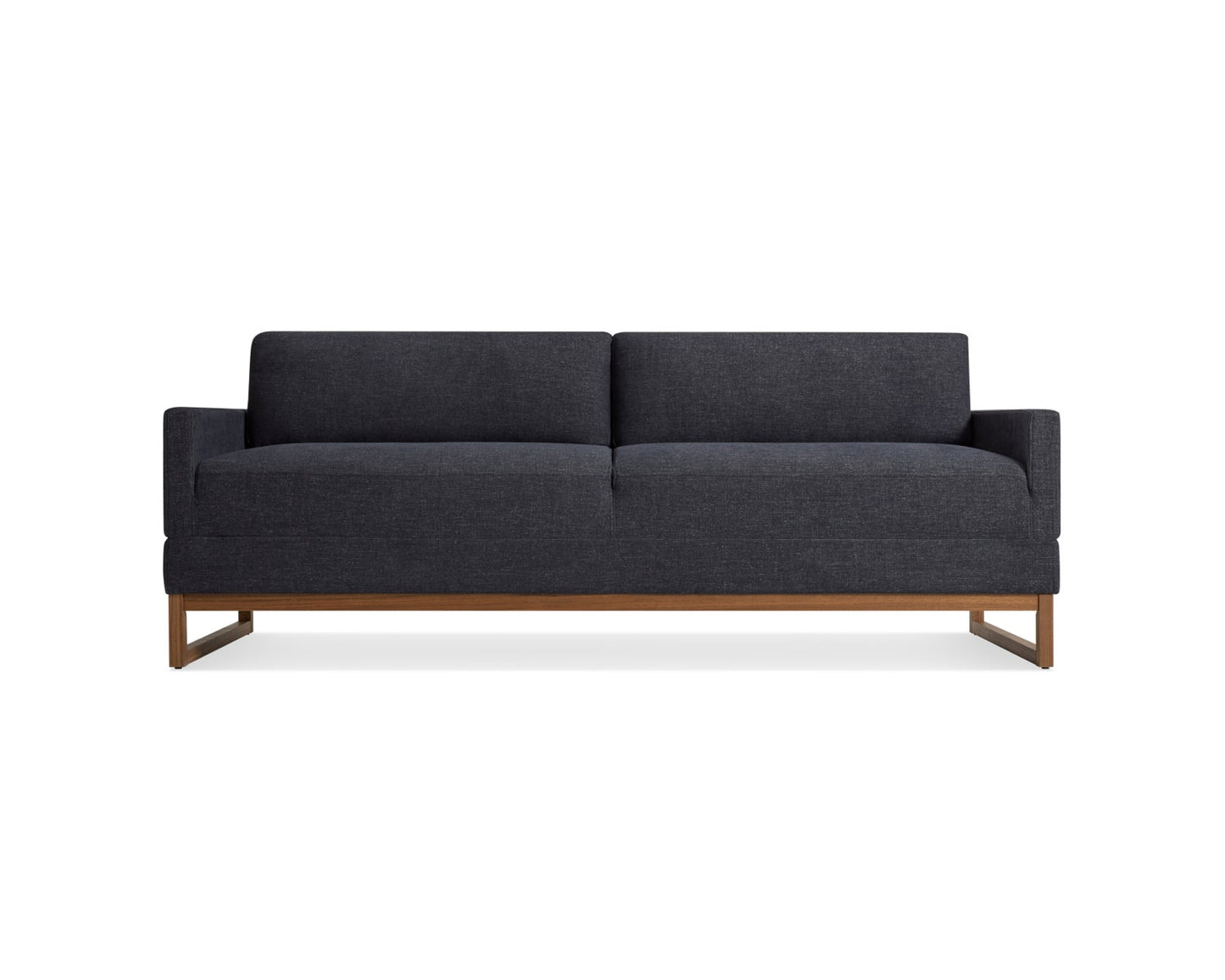 A modern dark gray sofa with a minimalist design featuring boxy armrests and cushions. It has a wooden base with legs and a sleek silhouette, set against a white background.