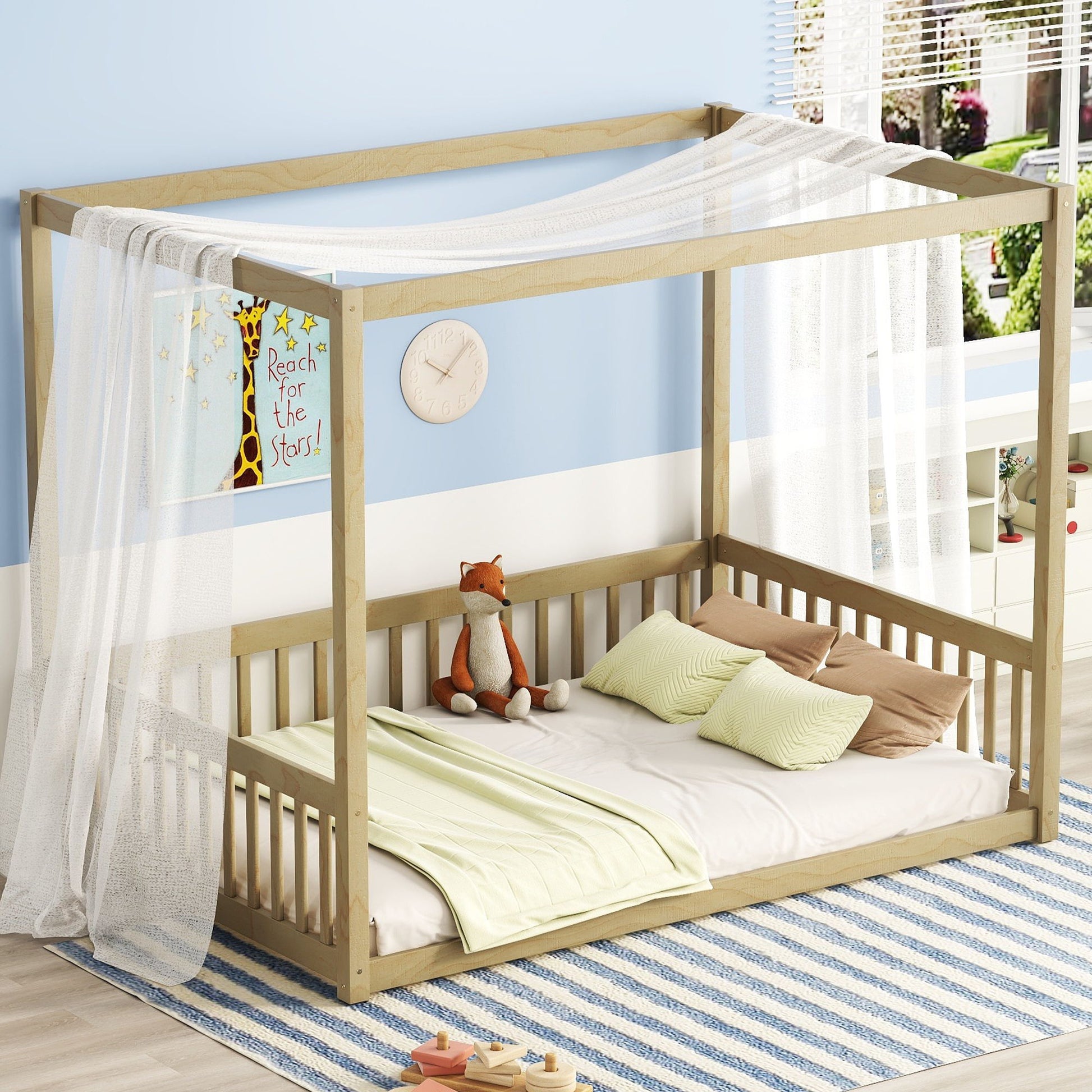 A cozy children's room with a "Canopy Frame Floor Bed With Fence, Guardrails" features a wooden frame and sheer white canopy. It includes a fox plush toy, striped pillows, and a green blanket. The room has blue walls, a clock, giraffe poster, and striped rug on the floor.