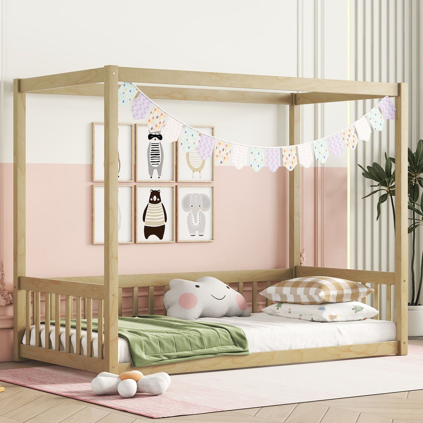 A child's room with a Canopy Frame Floor Bed featuring guardrails, a light wood frame, and pastel bunting. The walls display animal art like a panda and elephant. Bedding consists of a green blanket, pillows, and a plush elephant. A potted plant is in the corner.