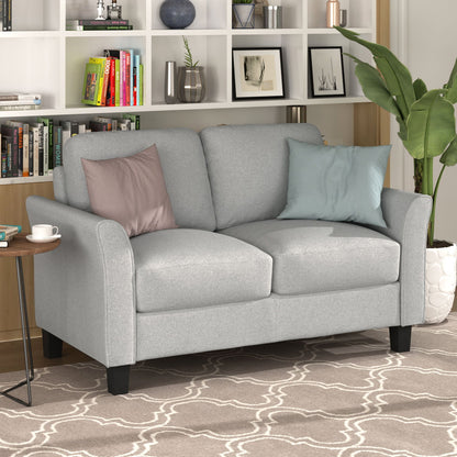 In the living room, the gray "Living Room Furniture Love Seat Sofa Double Seat Sofa Loveseat Chair" with two cushions is accompanied by a pink and a light blue throw pillow. Behind it, a white bookshelf showcases books and decor. A green plant in a white pot sits on the right.