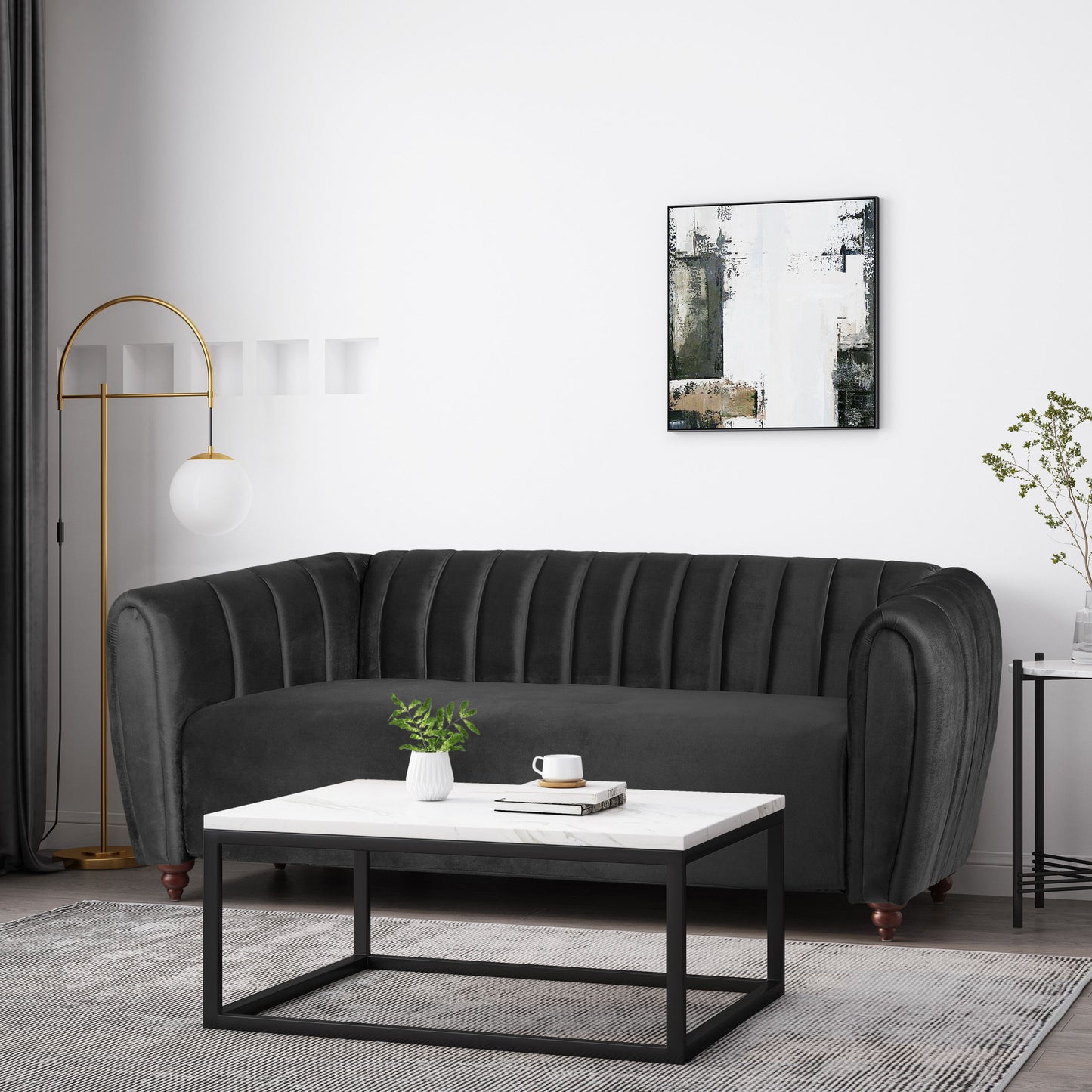 A modern living room showcasing a dark grey 3 Seater Sofa with curved arms, an abstract black and white painting, a tall gold lamp with a spherical bulb, a monochrome coffee table, and a plant on the side table.