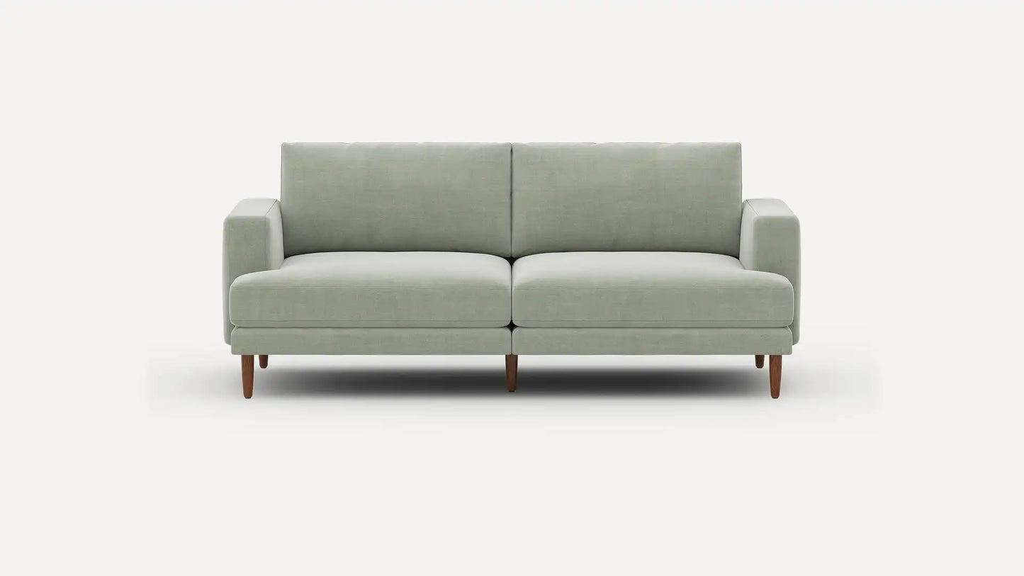 The Ember Mid-Century Modern 75" Sofa, featuring a light gray design with clean lines and wooden legs, is showcased against a plain white background.