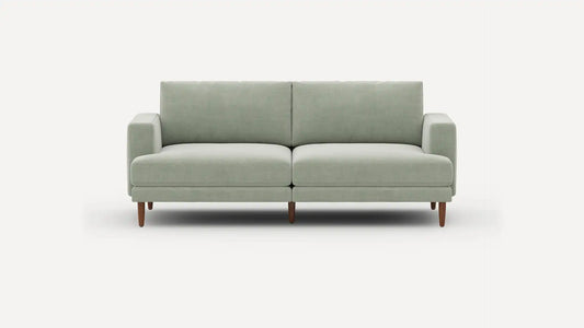 The Ember Mid-Century Modern 75" Sofa, featuring a light gray design with clean lines and wooden legs, is showcased against a plain white background.