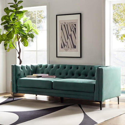 A camel, button-tufted faux leather sofa from JAYDEN CREATION's Eridu Collection graces a bright room with large windows. A tall plant is to the left, and a modern art print hangs above the sofa. The rug features abstract black and white patterns.