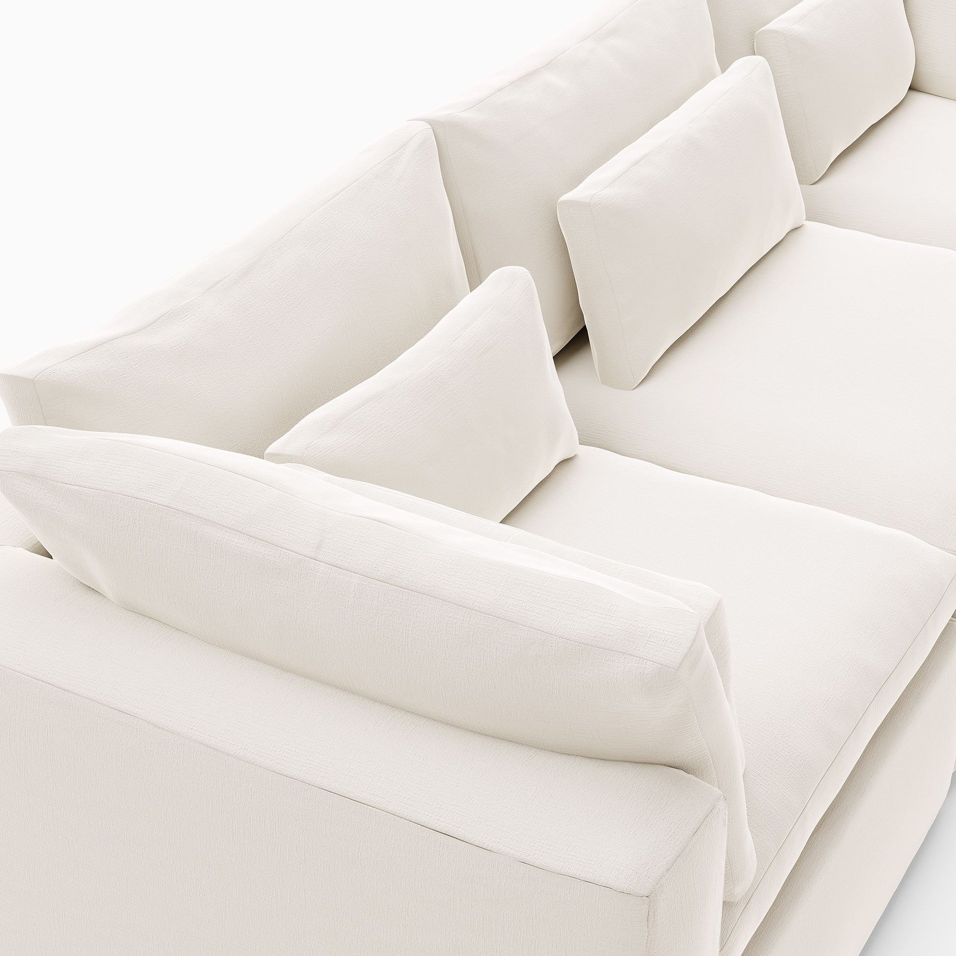 A top-side angle view of the Harmony Modular 3 Piece Sofa in white reveals its modern design with plush, rectangular cushions. The soft, luxurious fabric enhances its clean and minimalist aesthetic, making it an ideal addition to a living room setup.