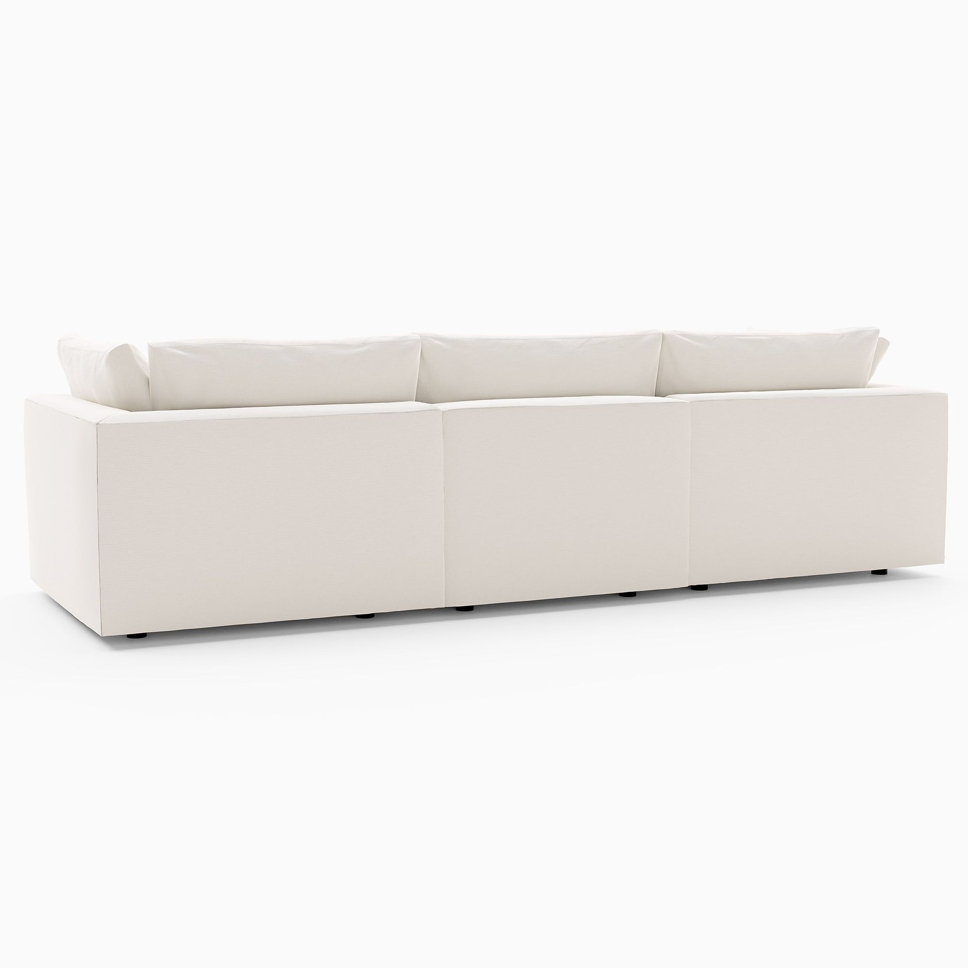 The Harmony Modular 3 Piece Sofa, featuring a large and modern white sectional design with minimalist aesthetics and low cushions, is showcased against a plain white background. This sofa comprises three interconnected segments, offering a sleek and contemporary look.