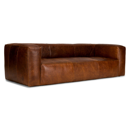 The Cigar 92" Leather Sofa in Rawhide Tan showcases a minimalist design with deep seat cushions and wide armrests, displayed against a plain white background. The leather offers a smooth, polished finish.