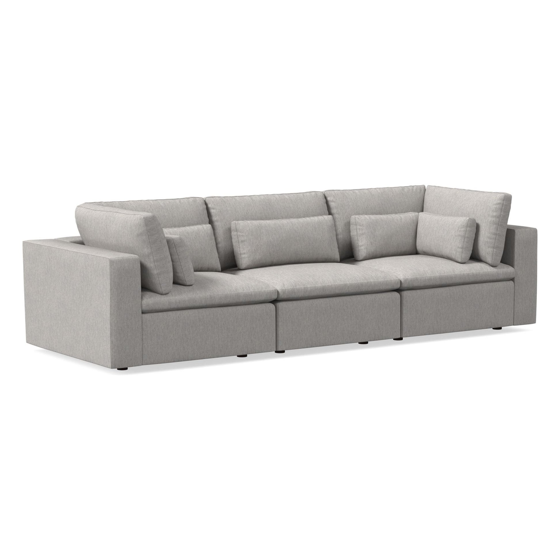 The Harmony Modular 3 Piece Sofa is a light gray sofa featuring three sections and a contemporary design with thick, cushioned seats and backrests. It includes additional rectangular accent pillows for enhanced comfort and exhibits a clean, minimalist aesthetic.