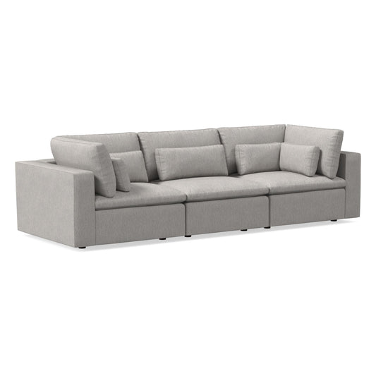 The Harmony Modular 3 Piece Sofa is a modern sectional in light gray with a minimalist design. It includes three segments, featuring thick seat and back cushions along with armrests on both sides, set against a white background.