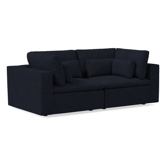 The Harmony Modular 3 Piece Sofa is a modern sectional in dark blue, characterized by its minimalist design with thick cushions on the seat and backrest, two armrests, and a textured fabric upholstery finish.