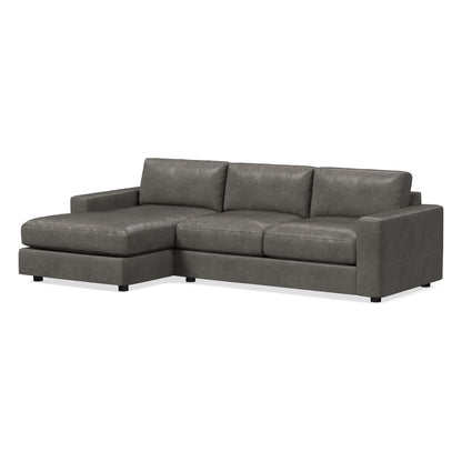 Introducing the Urban Leather 2 Piece Chaise Sectional: a contemporary gray sectional sofa with an L-shaped design, featuring wide arms and low-profile cushions. The left side boasts a chaise lounge extension, and it is upholstered in a smooth, leather-like material.