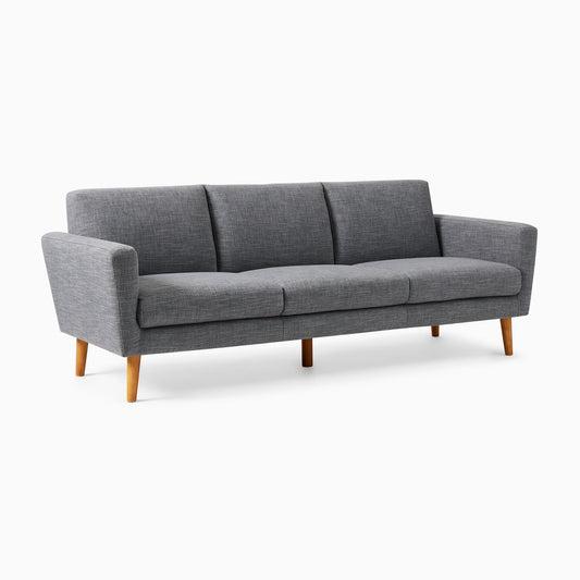 A contemporary gray Oliver Sofa featuring three cushions and wooden legs, displayed against a white backdrop. The sofa boasts a minimalist design with clean lines and subtly angled armrests.