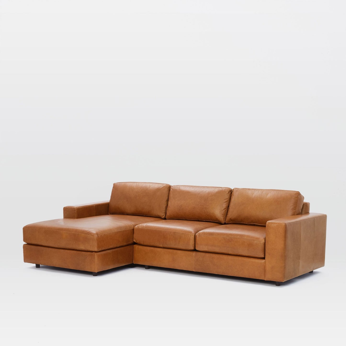 Urban Leather 2 Piece Chaise Sectional in brown leather, featuring three cushions and a left-facing chaise, set against a white background.