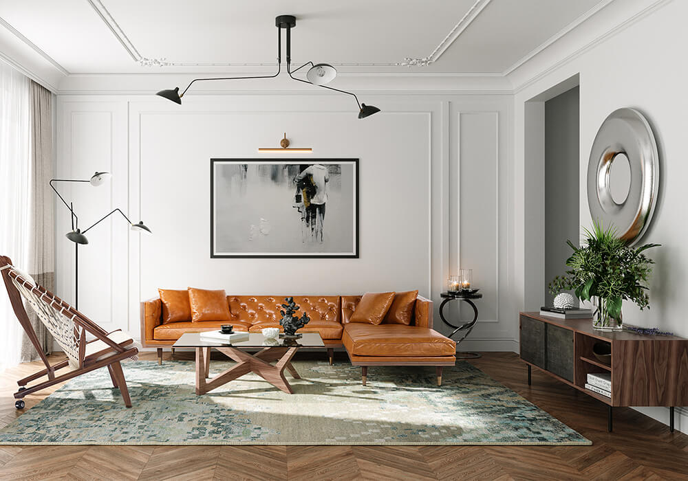 A modern living room features a brown leather sectional sofa with orange cushions, a wooden coffee table, and an abstract wall painting. A stylish standing lamp and a large round wall mirror enhance the space. A textured rug and houseplant add warmth and greenery.