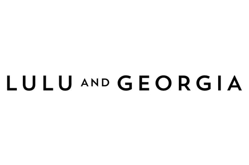 The image displays a logo with the text "LULU AND GEORGIA" in bold, black capital letters on a white background. The words are spaced evenly, with "AND" appearing in a smaller font size between "LULU" and "GEORGIA.