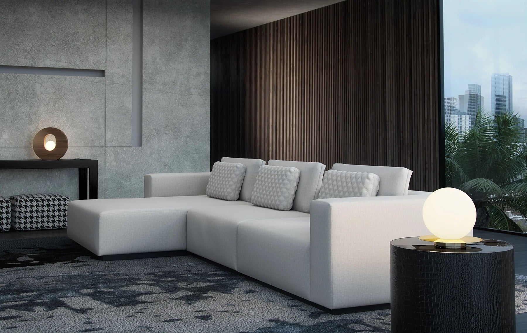 Modern living room with a white sectional sofa adorned with textured cushions, facing a round side table with a spherical lamp. The space features dark wooden paneling, a large window with a city view, and contemporary decor including a sleek console table and patterned objects.