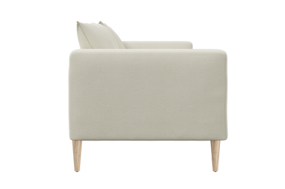 Side view of The Essential Loveseat, a minimalist beige sofa with light wood legs, featuring plush cushions. Its sleek and modern design showcases a clean and simple aesthetic.