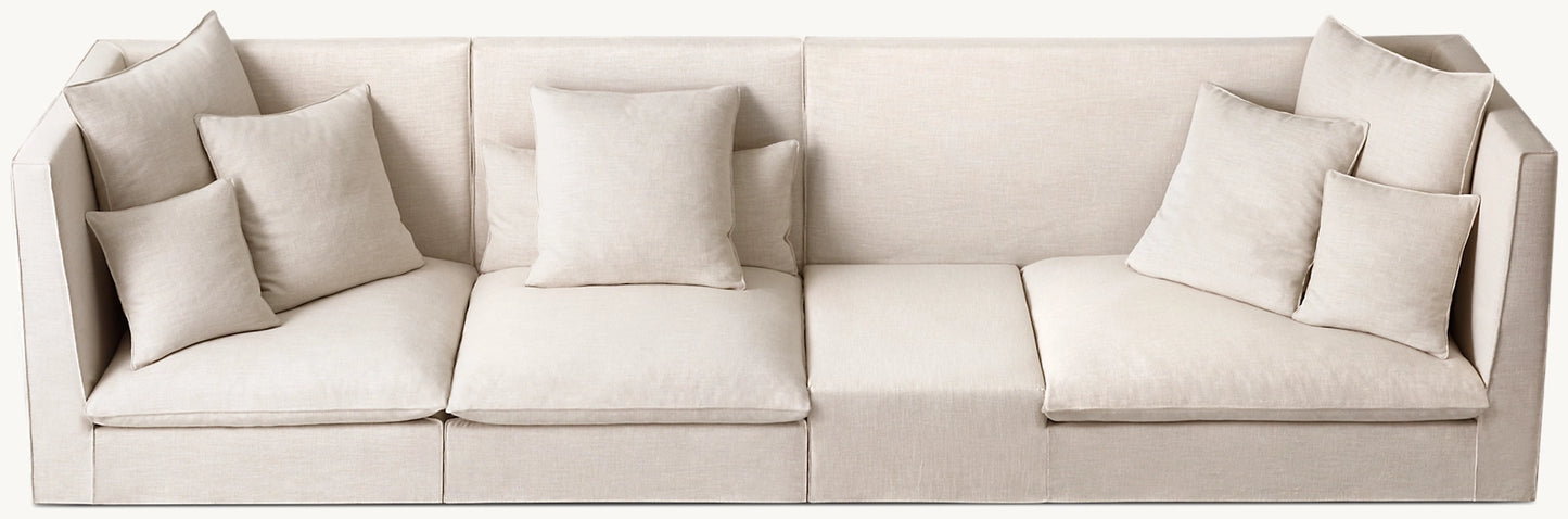 A spacious, beige, contemporary sectional sofa featuring clean lines and padded backrests. It includes five matching cushions distributed across its three sections. The soft and comfortable fabric ensures an inviting seating arrangement.