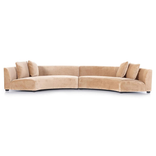 A white, curved sectional sofa named the Zoe Modern Performance features plush cushions against a white background. The design incorporates black birch wood and offers ample seating space with its soft, velvety texture.