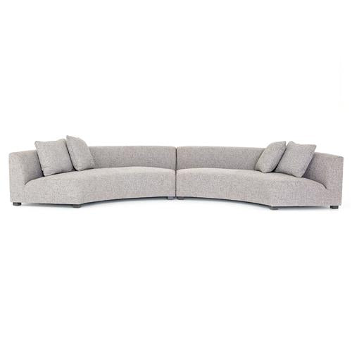 The Zoe Modern White Performance Black Birch Wood Piece Curved Sectional is a contemporary design in light gray, featuring two spacious sections that are joined together. Each section includes backrest cushions and additional throw pillows for enhanced comfort.