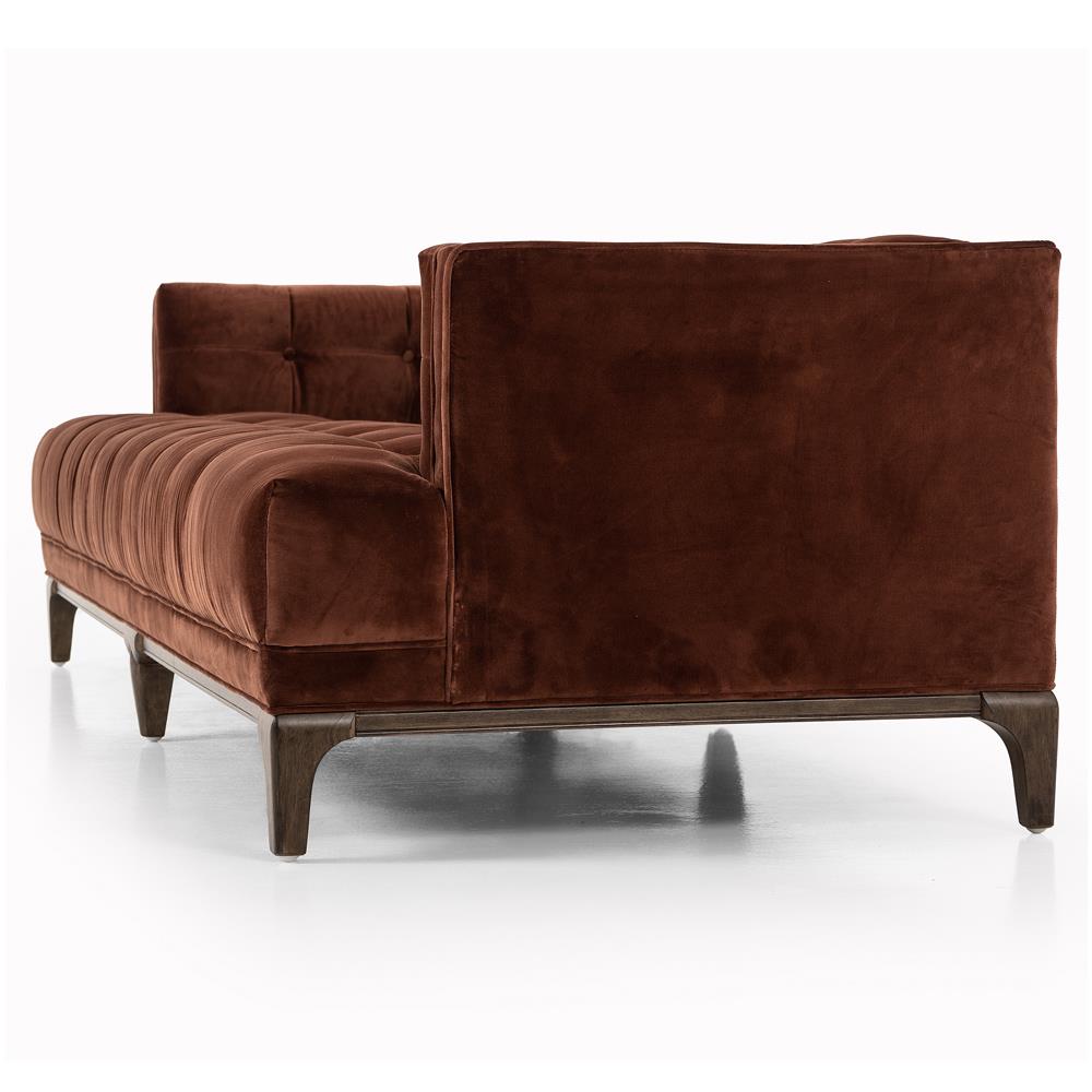 A green velvet sofa named the Allen Mid Century, featuring a brown wood frame with button tufting on the backrest and seat, viewed from the side. The sofa's design combines plush comfort and modern elegance. The angle of view emphasizes its sophisticated side and back features.