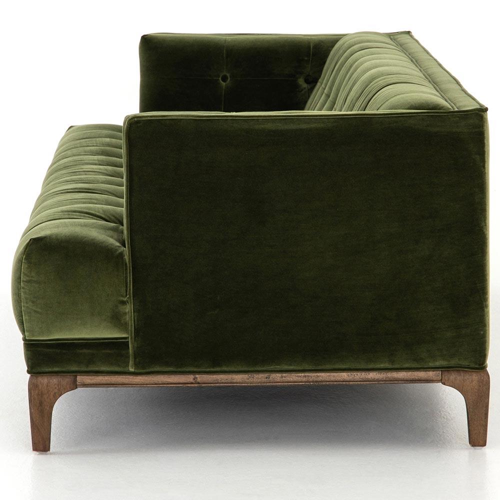 A side view of the Allen Mid Century Green Velvet Brown Wood Frame Button Tufted Sofa, showcasing its luxurious dark green velvet upholstery with a tufted back and seat. The sofa is designed with elegant wooden legs and is photographed against a plain white background.