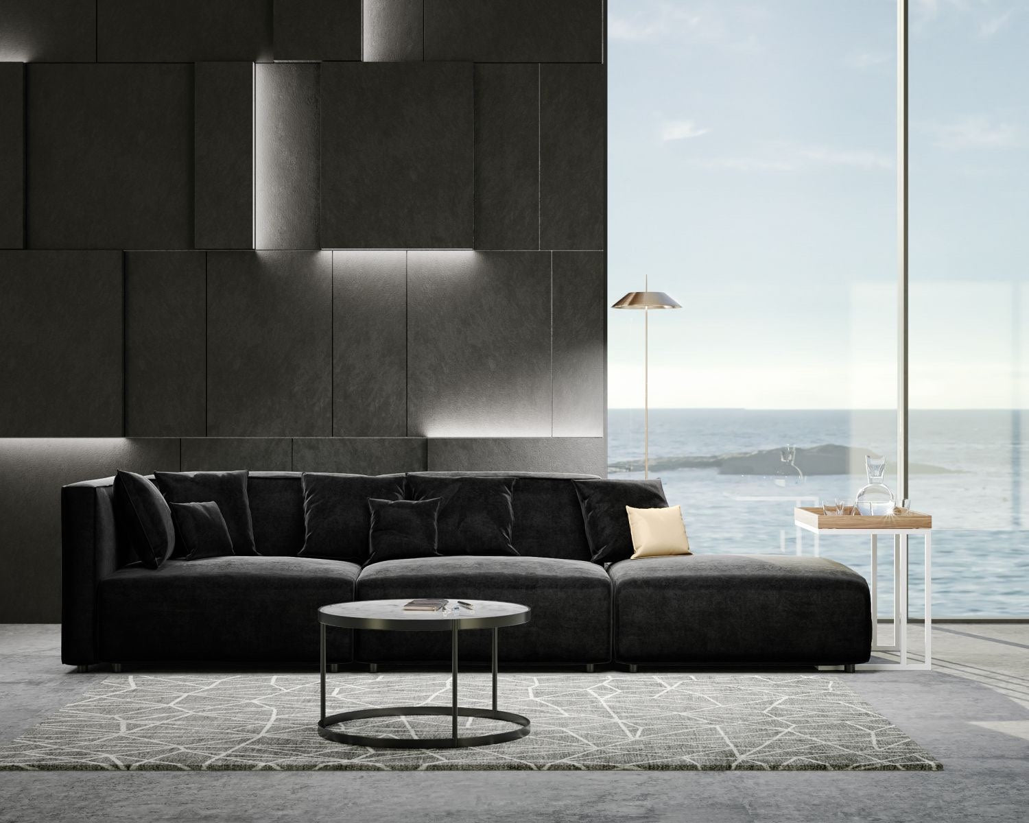 A modern living room with a large, dark sectional sofa, a circular coffee table on a geometric-patterned rug, and a floor lamp. The room has a large window with a view of the ocean, allowing natural light to illuminate the minimalist decor.