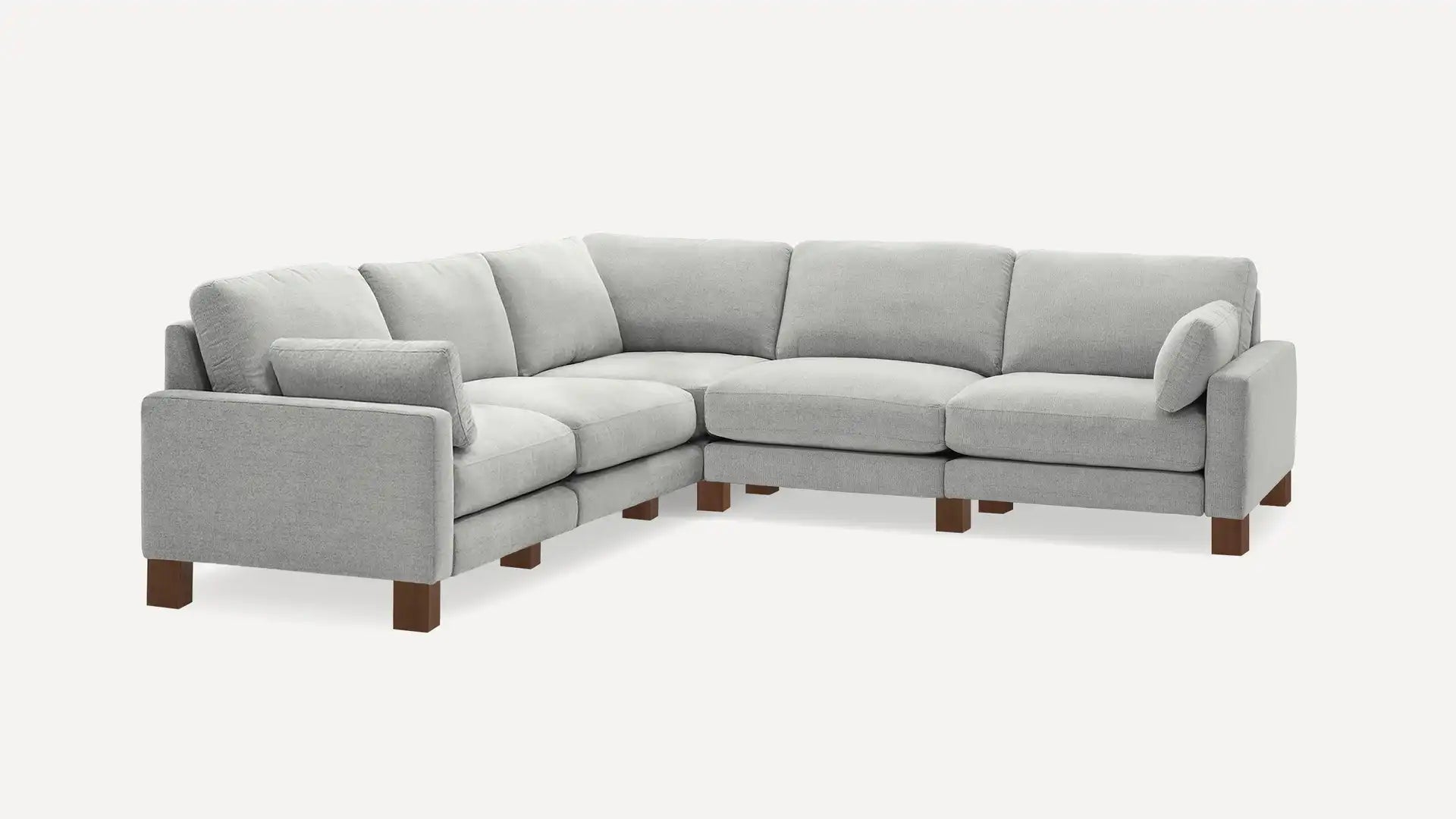 The Union Fabric Modular 5-Seat Sofa Sectional is a large, L-shaped gray sofa with wooden legs. It showcases a modern design with plush cushions and a sleek appearance, making it ideal for a contemporary living room setting.