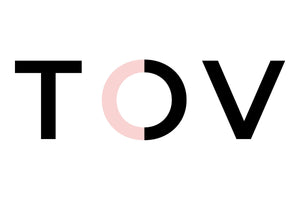 The image shows the letters "T", "O", and "V" in a large, bold font on a white background. The letter "O" is partially colored pink on the left side and black on the right side, while the "T" and "V" are entirely black.