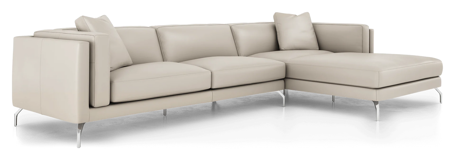 Introducing the Reade Sectional Sofa: a contemporary L-shaped design crafted in light beige leather. It showcases sleek, minimalist lines with chrome legs, and is complemented by matching back cushions and a pillow.