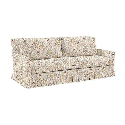 The Suzanne Kasler Mathes Sofa with Box Pleat Skirt is a beige and white patterned sofa featuring a paisley design on a white background. It comes with a fitted cover that reaches the floor for a tailored appearance, along with two seat cushions and an extended backrest cushion.