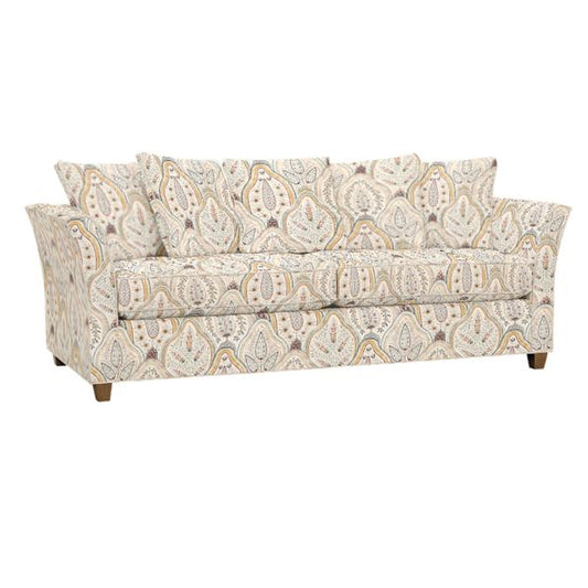 The Tate Queen Sleeper is a patterned sofa adorned with a paisley design in beige, blue, and gray tones. It comes with three seat cushions and several matching throw pillows, showcasing its wooden legs at the bottom.