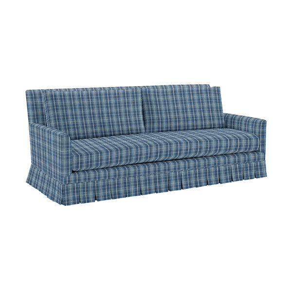 The Suzanne Kasler Mathes Sofa with Box Pleat Skirt features a blue plaid design with a checkered fabric pattern, three seat cushions, and a clean, simple style. The plain white background accentuates the sofa's elegant design.