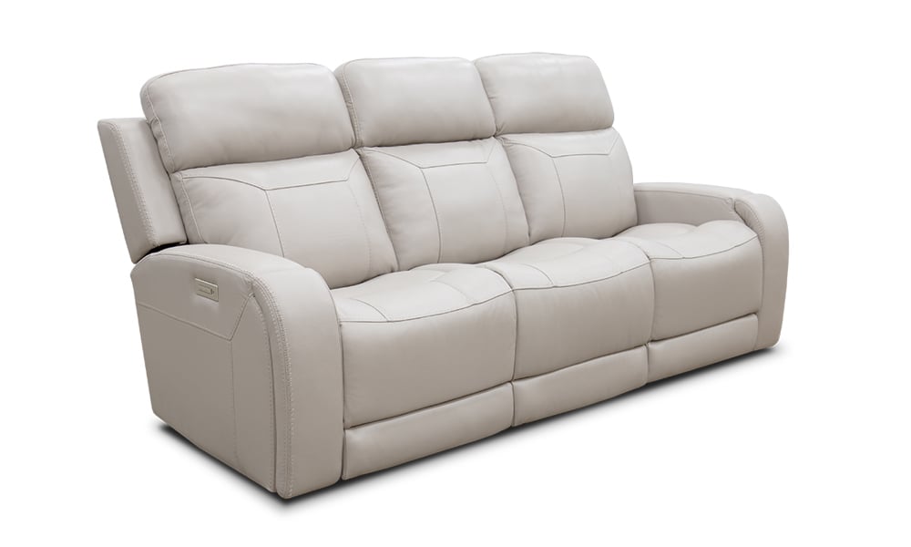 The Maverick Dove Leather Power Media Sofa is a beige reclining sofa featuring three cushioned seats and padded armrests. Its design includes visible stitching and a modern, comfortable style, all set against a white background.