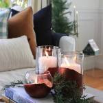 City Farmhouse lifestyle and home decor and interior design blog. Glass candle holders with painted metallic maroon bases. White upholstered sofa with Christmas themed ornaments.
