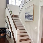 Thrifty Decor Chick lifestyle and home decor blog. Phot shows a white Colonia stairwell, natural wood and painted white steps, white walls, gallery wall photos
